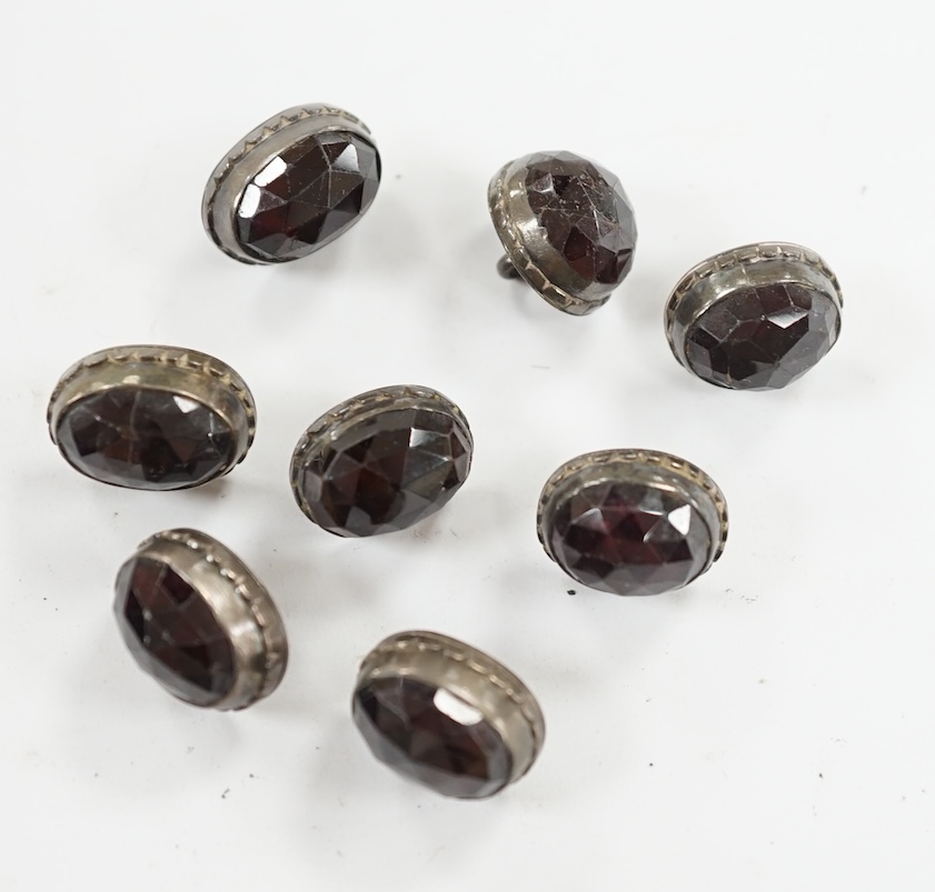 A set of eight 19th century white metal and facetted garnet set buttons, 12mm. Condition - fair but wear to the stones